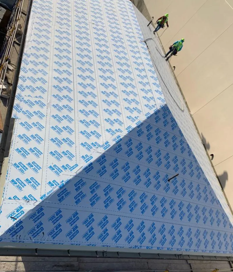 Professional roofers installing underlayment on a metal roof in Orangetown